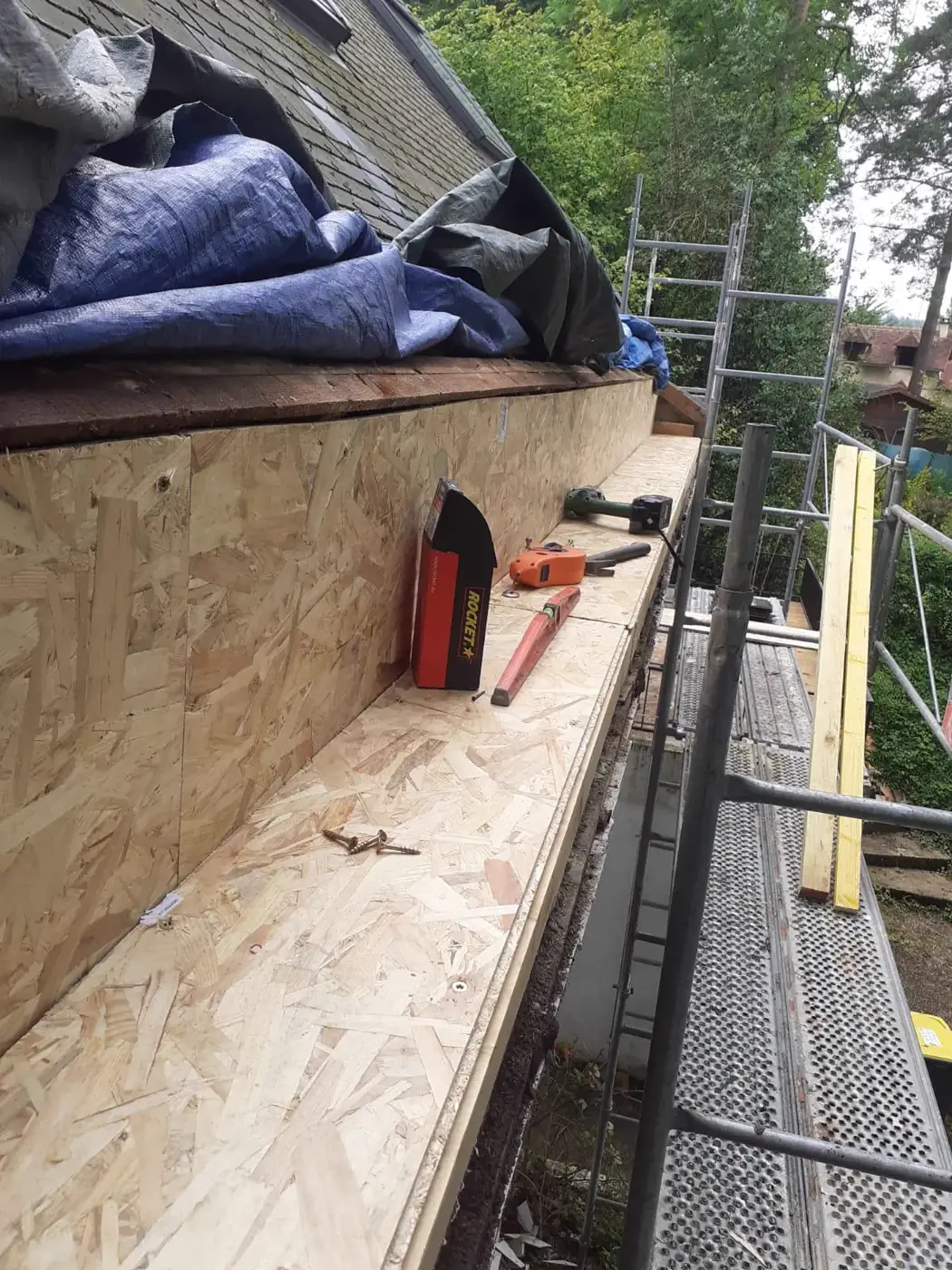 Support en bois du chéneau encaissé en cours de réfection sur une toiture en ardoise à Mortefontaine-en-Thelle