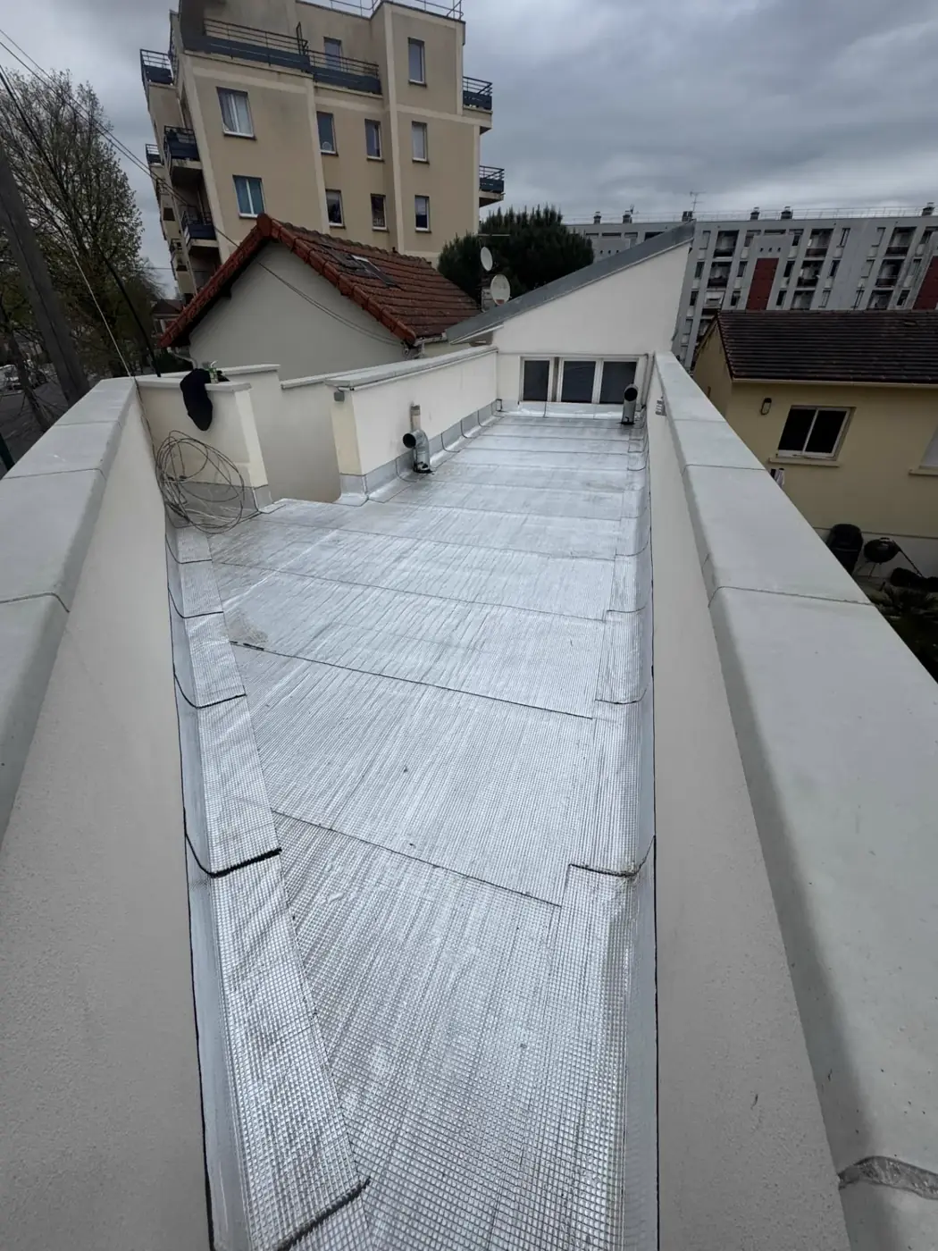 Terrasse étroite reprise en étanchéité bitumineuse à face alu Vernal entre deux murs acrotères à Épinay-sur-Seine
