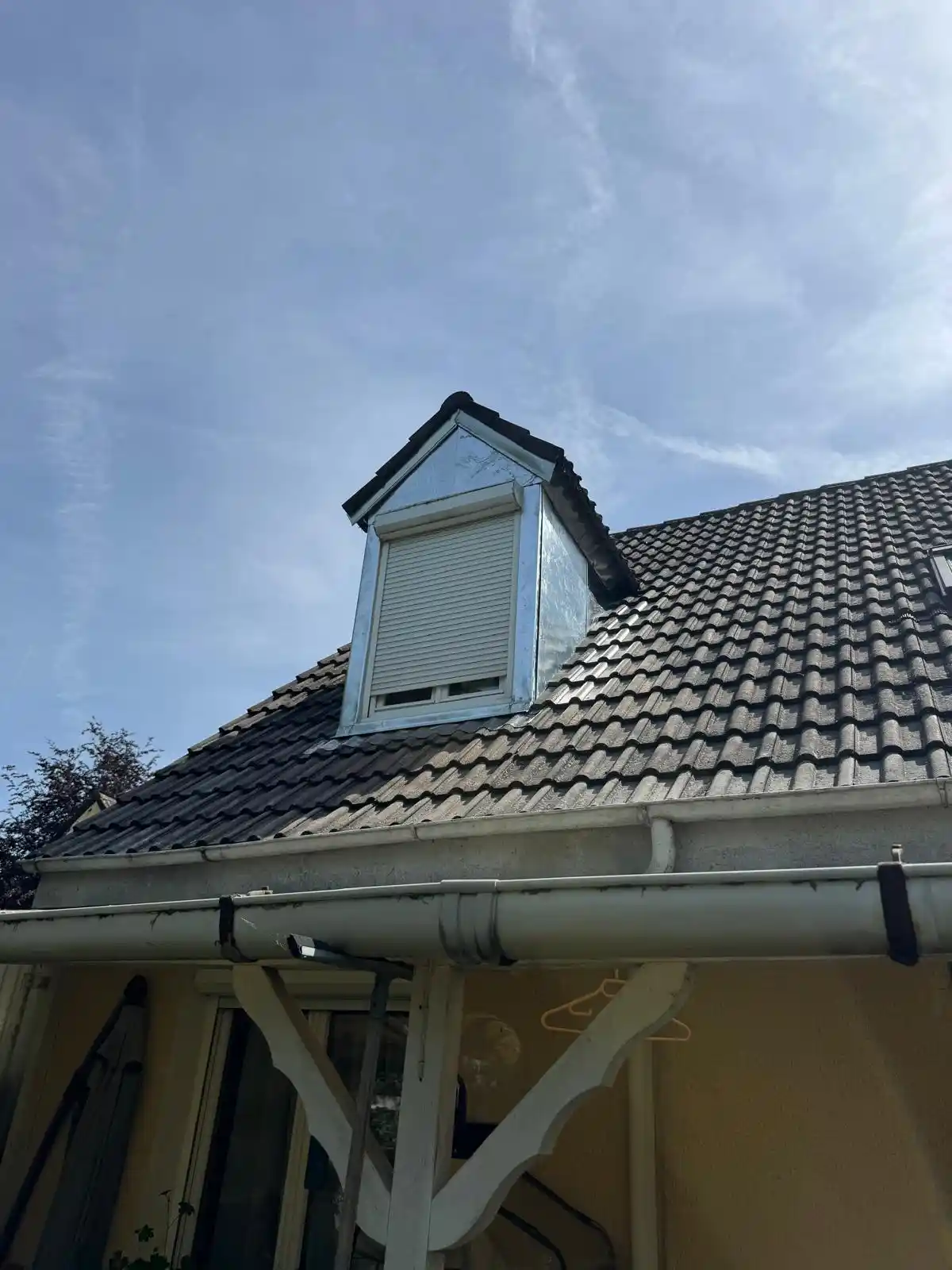 Lucarne rénovée à Chelles avec habillage zinc et volet roulant, sur toiture en tuiles