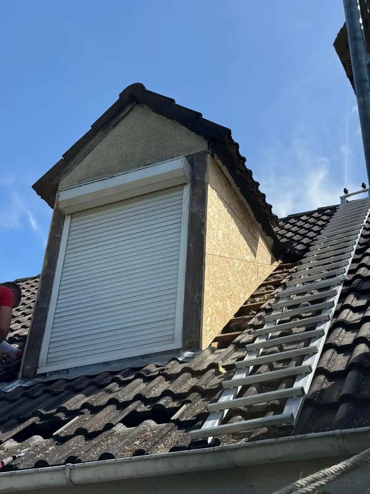 Lucarne en cours de rénovation à Chelles : volet roulant posé et couverture en cours de reprise
