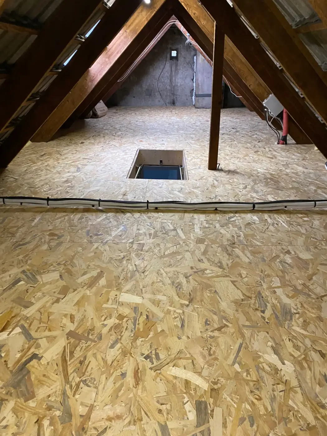 Plancher en panneaux OSB posé dans un comble perdu à Limeil-Brévannes, charpente apparente et isolation sous rampants